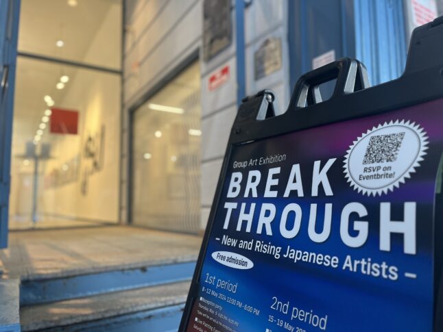 ギャラリーの出入り口に、グループ展のキャッチコピー「BREAKTHROUGH」が書かれたポスターが置かれている